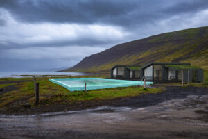 Reykjafjardarlaug Hot Pool with views over ocean and mountains located in the Westfjords region of Iceland.